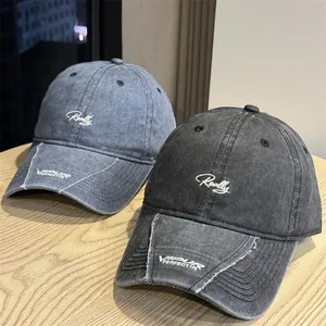 Primer plano de dos gorras vintage lavadas con bordado de letras Really y borde gastado
