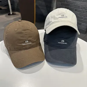 Primo piano di tre berretti da baseball in stile coreano con logo numero otto ricamato