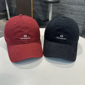 Vista dettagliata dei cappellini da baseball bordeaux e neri con ricamo del logo '8'