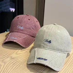Detalle de gorras de béisbol vintage lavadas con bordado cursivo y diseño de copa blanda