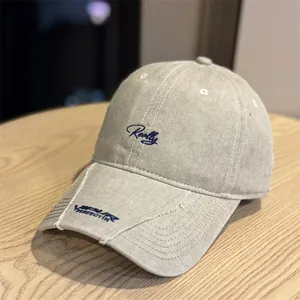 Vista detallada de una gorra de béisbol vintage lavada caqui con bordado azul 'Really'.