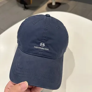 Dettaglio di un cappellino da baseball in cotone blu scuro con ricamo bianco numero 8