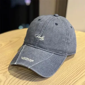 Primer plano de una gorra de béisbol vintage gris lavado con bordados de letras