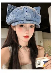 Modell trägt eine vintage blau gepunktete Schirmmütze mit süßem Katzenohr-Design