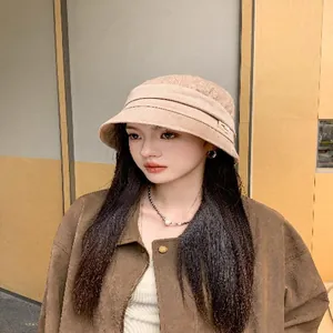 Close-up of a stylish khaki autumn fisherman hat worn by an Asian model indoors