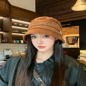 Detail view of a stylish brown Korean-style bucket hat worn by a model in a cozy cafe.