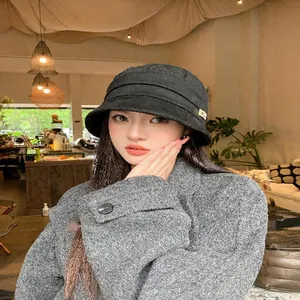 Close-up of a stylish Korean black wool bucket hat with wide brim on a female model