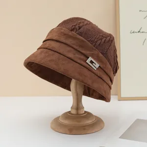 Detailed shot of a brown knit and suede bucket hat featuring a sparkly rhinestone buckle