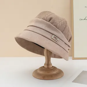 Close-up detail of stylish beige bucket hat featuring rhinestone G-buckle and knit texture