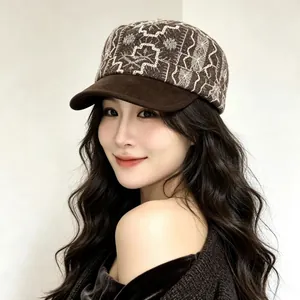 Close-up of a stylish vintage brown flat cap with intricate white embroidery pattern