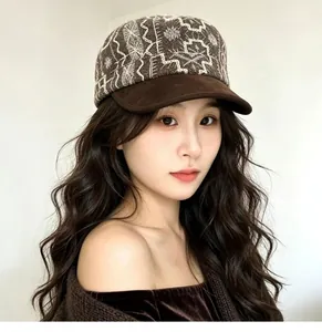 Detailed view of a vintage brown embroidered flat cap styled on a fashion model.