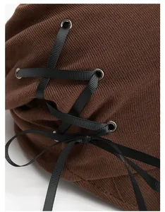 Dettaglio cappello pescatore in maglia a coste marrone con lacci decorativi in nastro