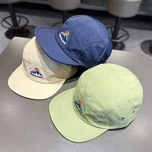 Dettaglio di tre cappellini a cinque pannelli ad asciugatura rapida con ricamo.