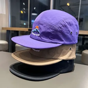 Dettaglio ravvicinato di cappelli camper a 5 pannelli con ricamo a tema montagna.