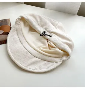Detail view of an off-white beret with adjustable drawstring interior for perfect fit.