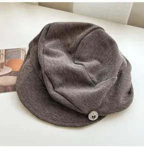 Detailed view of the vintage brown corduroy pleated beret hat with a heart button