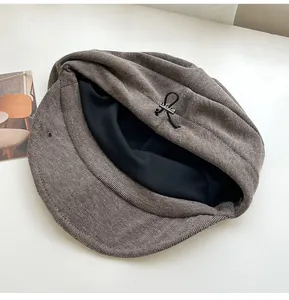 Close-up of retro corduroy beret showing soft black lining and adjustable buckle