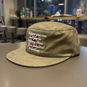 Detail of olive green flat top military cap featuring white inspirational embroidery