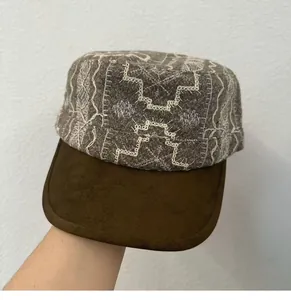 Detailed view of a vintage embroidered cadet cap featuring a brown suede brim and patterns