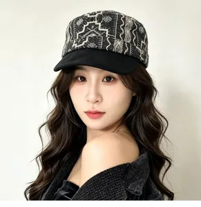 Close-up view of a chic retro flat cap with intricate white embroidery on a model