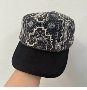 Close-up detail of retro embroidered cadet cap with intricate white stitching pattern