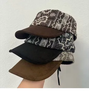 Close-up of three vintage embroidered flat caps in brown, black, and tan colors