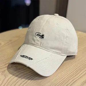 Primer plano de una gorra de béisbol beige de estilo vintage con bordado negro