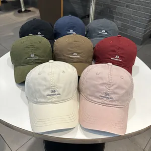 Dettaglio di vari colori di cappellini da baseball minimal con ricamo del numero 8