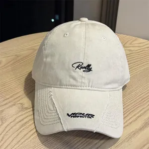 Vista detallada de gorra de béisbol beige lavada con bordado Really en cursiva