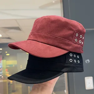 Detail of cotton flat top military caps in red and black with metallic eyelet decorations