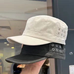 Detailed side view of cotton military caps in beige and black with metal eyelet decorations