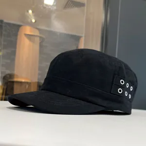Close-up detail of a black cotton flat top military cap with silver metal eyelets.