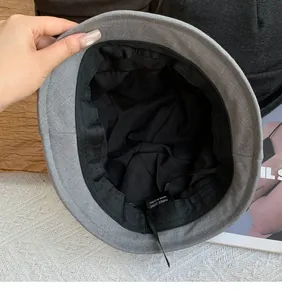 Detailed internal view of a grey pleated bucket hat featuring black lining and sweatband