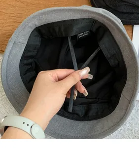 Detail view of the interior lining and adjustable drawstring of a grey bucket hat