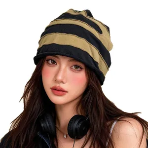 Elegante gorro de invierno a rayas y bufanda de doble uso usado por una modelo