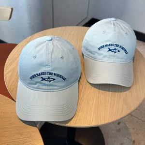 Light blue washed cotton baseball cap featuring navy small fish embroidery and text design