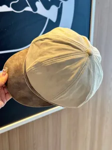 Close-up of newsboy hat with brown PU brim and beige suede texture detail