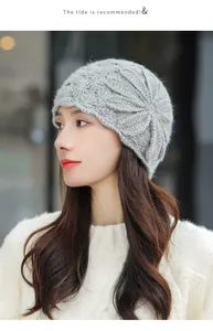 Close-up detail of an elegant grey mohair knitted beanie with a floral pattern on a model
