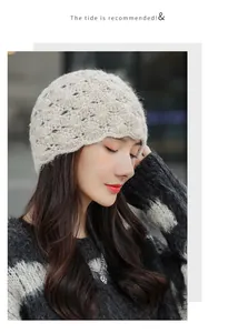 Detail view of a vintage beige mohair hollow knit beanie hat worn by a female model.