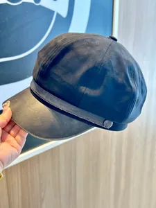 Close-up detail of a stylish navy newsboy hat with faux suede and PU leather brim