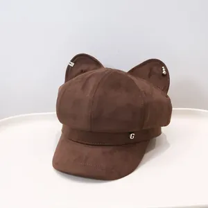 Detailed shot of a brown suede octagonal beret featuring cute cat ears and a metal G logo