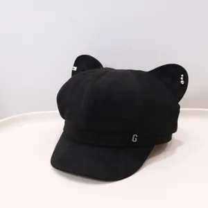 Close-up of a black newsboy hat with cute cat ears and a silver metal G logo detail.