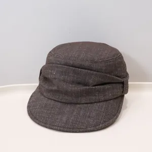 Detailansicht einer braunen Vintage-Kadetmütze mit gefalteter Stoffstruktur und flachem Oberteil.