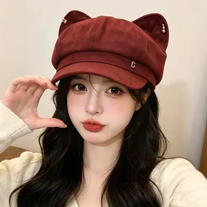 Stylish woman wearing a cute burgundy octagonal hat with cat ears and metal G detail