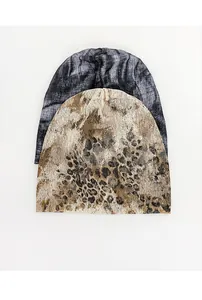 Two thin retro slouchy beanies featuring leopard and marble patterns on white background
