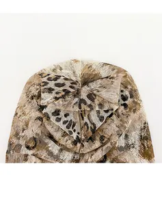Close-up detail of vintage leopard print thin beanie with top bow decoration