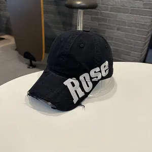 Détail d'une casquette de baseball noire en coton lavé avec broderie ROSE et effet usé
