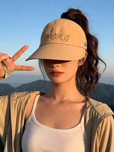 Dichtbij van een stijlvolle beige zonneklep met borduursel voor de zomerse bescherming.