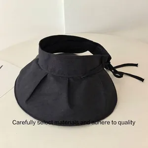 Macro view of black wide-brim sun visor hat with foldable pleated design