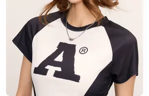 Detailansicht eines High-Street-T-Shirts mit Halskette und grafischem Druckakzent
